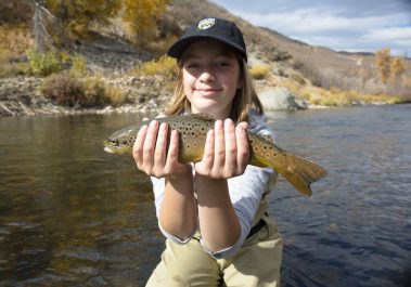A girl holding a trout on one of the Park City and Utah rivers we fish