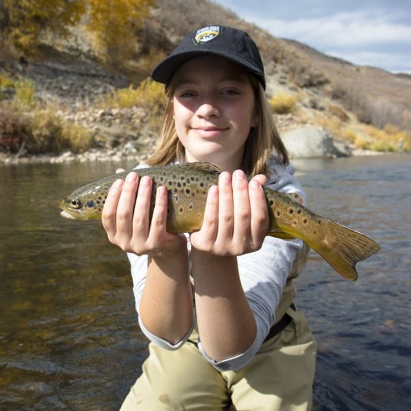A girl holding a trout on one of the Park City and Utah rivers we fish