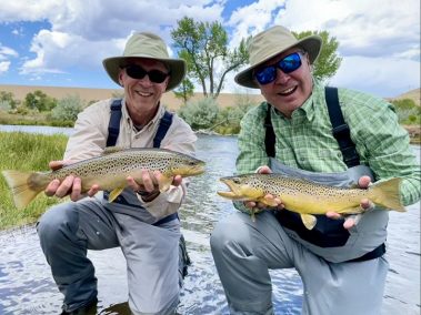 Two Jeremy Allan Fly Fishing clients holding big brown trout.