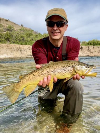 A Jeremy Allan Fly Fishing client holding a large brown trout