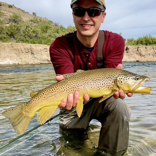 A Jeremy Allan Fly Fishing client holding a large brown trout