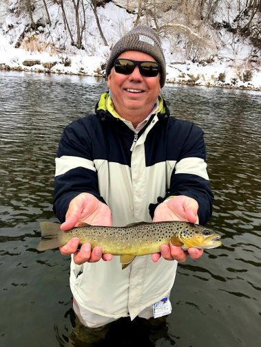 Fly Fisherman holding a brown trout on the Provo River