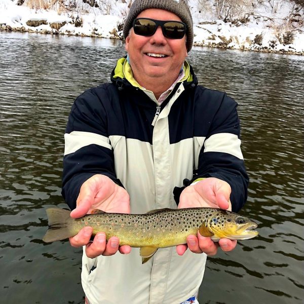 Fly Fisherman holding a brown trout on the Provo River