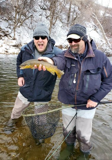 Winter fly fishing in Utah, Jeremy Allan holding a brwon trout caught on the Provo River