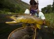 Lady holding a big brown trout caught during a Green Drake hatch.