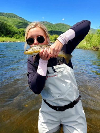 A girl kissing a brown trout caught on the Provo River