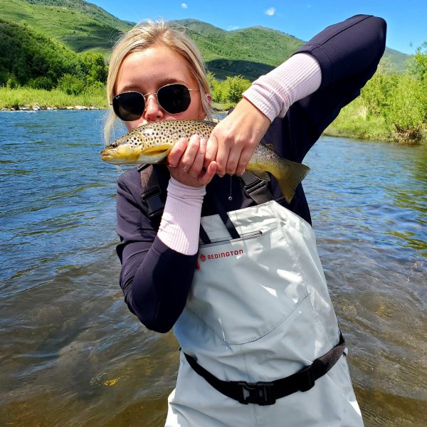 A girl kissing a brown trout caught on the Provo River
