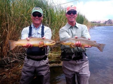 Two fly fisherman each with twenty inch brown trout