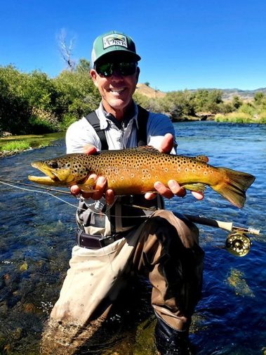Fly Fisherman with a big brown trout on the Weber River