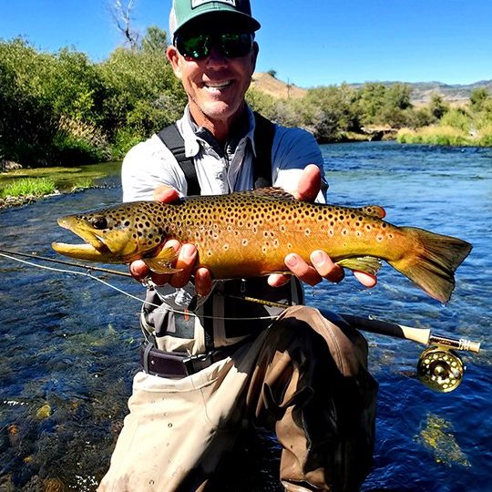 Fly Fisherman with a big brown trout on the Weber River