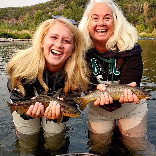 Mother and daughter fly fisherman with 2 brown trout caught on the Provo River