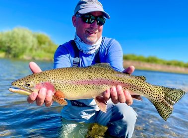 A Jeremy Allan Fly Fishing customer with a big rainbow trout caught on a small stream in Wyoming