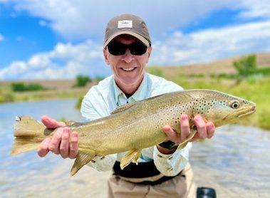 A Jeremy Allan Fly Fishing customer with a big brown trout on a small stream in Utah