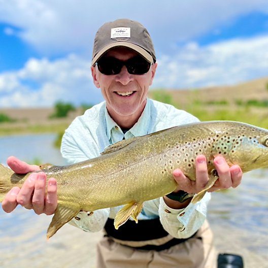 A Jeremy Allan Fly Fishing customer with a big brown trout on a small stream in Utah