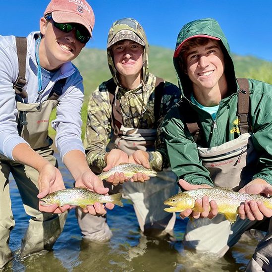 Three happy fisherman with brown trout on the Provo River
