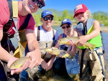 A family with three brown trout caught on the Provo River