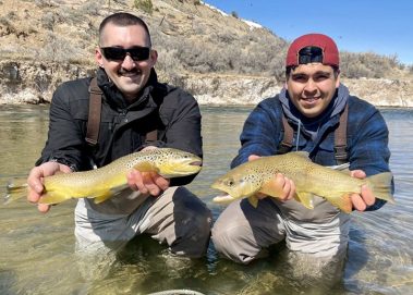 Two fly fisherman each with a nice brown trout caught on a small stream in Utah.