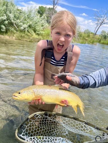 A very excited girl with a big brown trout caught on a Utah stream