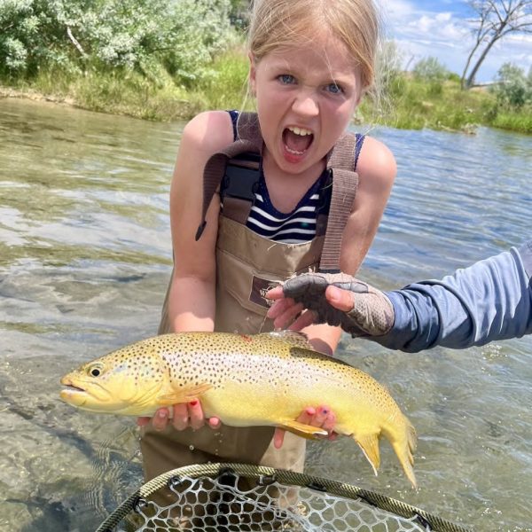A very excited girl with a big brown trout caught on a Utah stream
