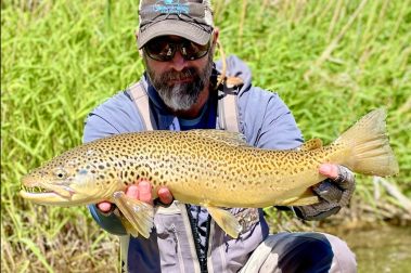 Guide Jeremy Allan with a big brown trout caught on a small stream trip