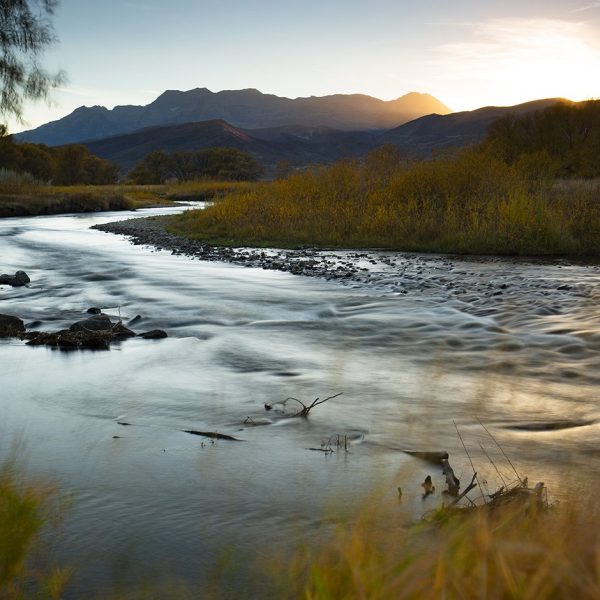 A long exposure photograph of the Provo River and Mt. Timpanogas with Fall colors by Jeremy Allan