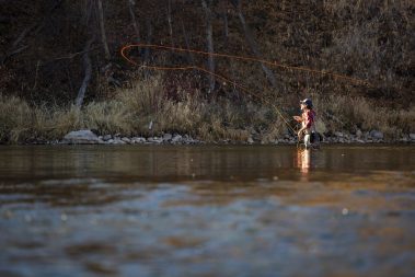 A fly fisherman casting a dry fly on the Provo River