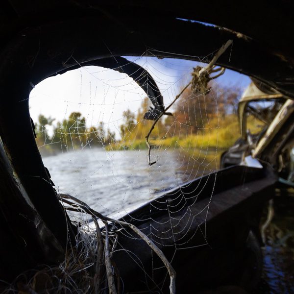 A spider web in the window of an old car looking into the Weber River. Fine art prints by Jeremy Allan