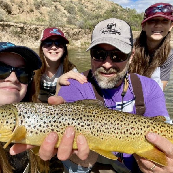 Salt Lake City fly fishing guide and photographer Jeremy Allan with family and holding a brown trout. Took the family out for a fun day of fishing on a Utah river. We had a lot of fun and caught some nice brown trout.
