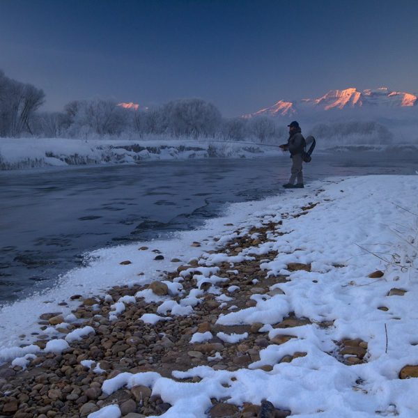 A fly fisherman standing in the Provo River during the Winter