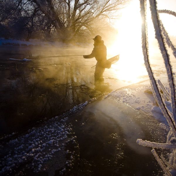 A fly fisherman standing in the Provo River during the Winter
