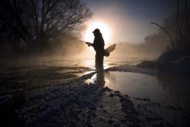 A fly fisherman standing in the Provo River during the Winter
