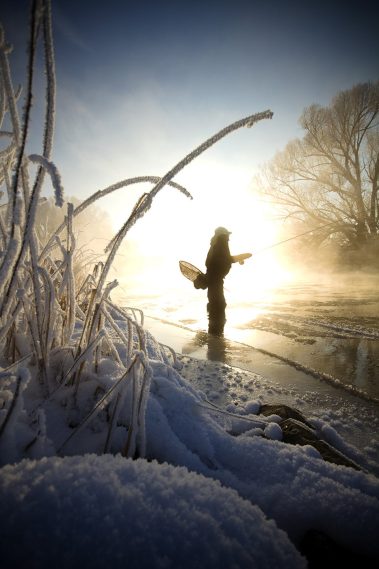 A fly fisherman standing in the Provo River during the Winter