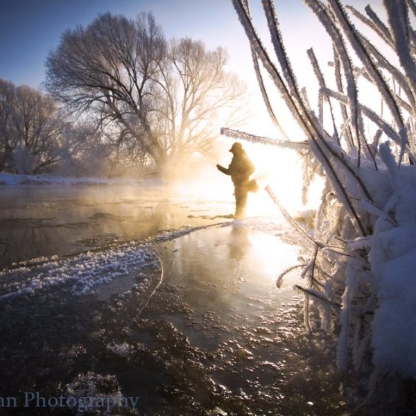 A fly fisherman standing in the Provo River during the Winter