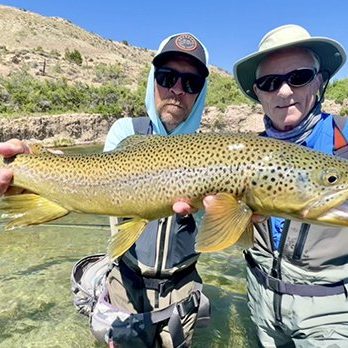 A fly fishing guide and client with a big brown trout caught on a guided fly fishing trip in Utah with Jeremy Allan