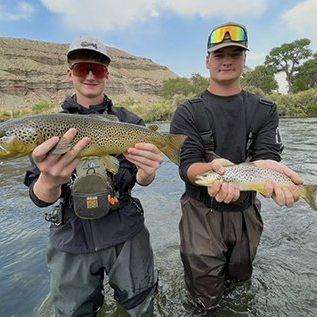 Two brothers holding brown trout caught in Utah
