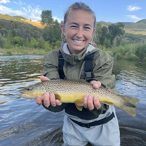 A happy girl holding a trout caught on the Provo River while fly fishing with Jeremy Allan Fly Fishing