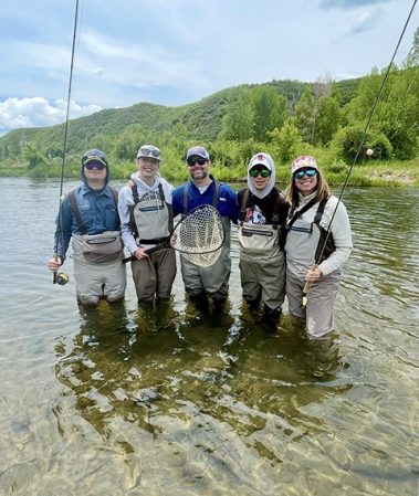 Happy family standing in the river after a great day fly fishing on the Provo River in Utah