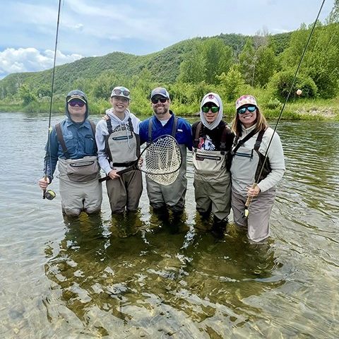Happy family standing in the river after a great day fly fishing on the Provo River in Utah